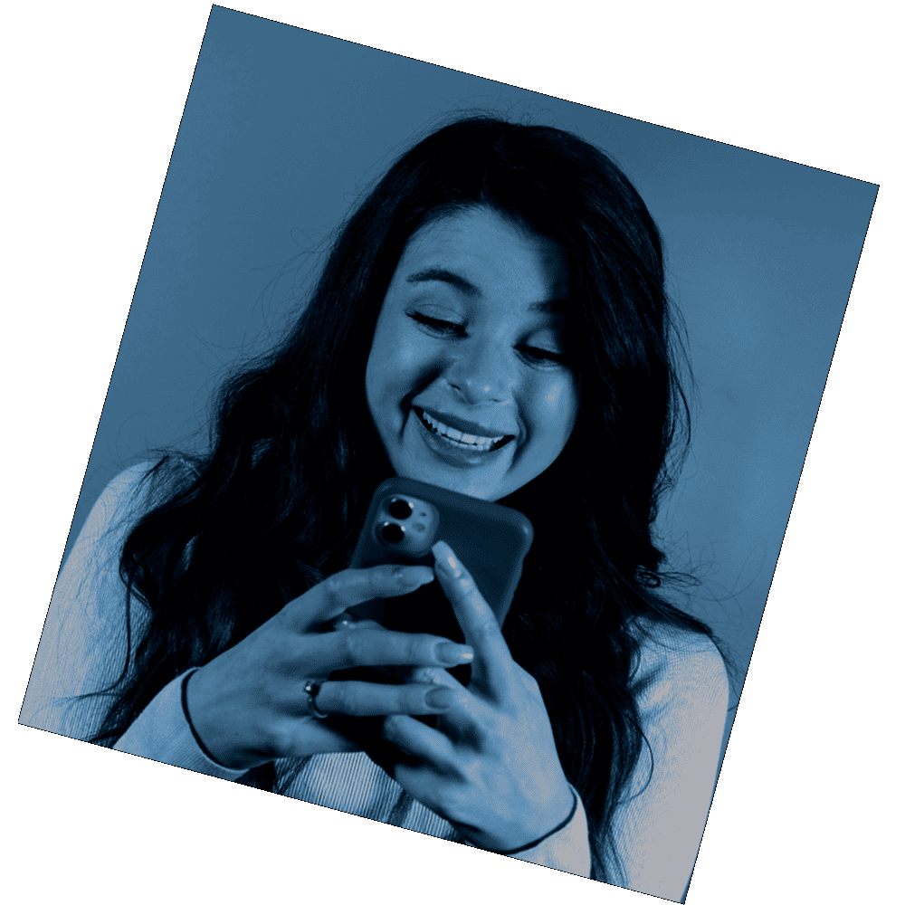 Una mujer sonriente usando su teléfono móvil.